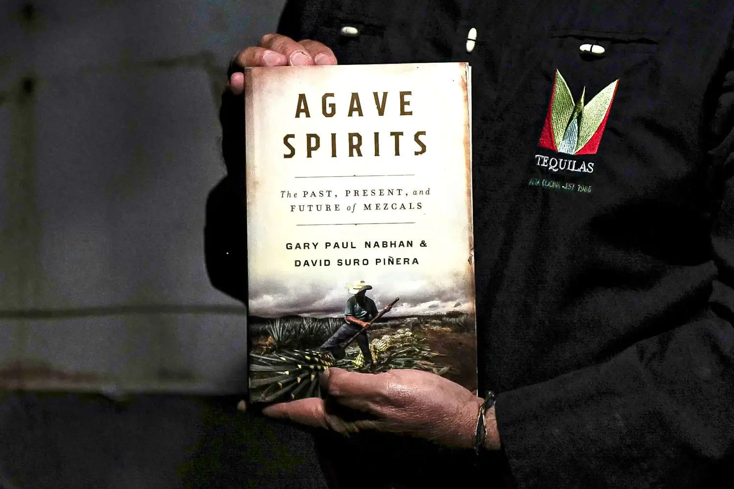 David Suro-Piñera holding a copy of Agave Spirits, showing cover