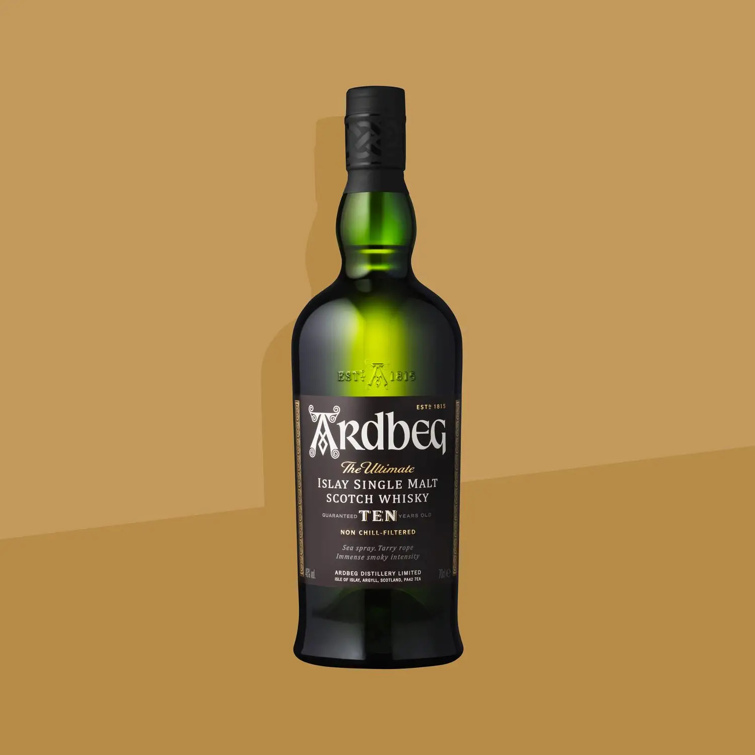Ardbeg 10-Year Islay Single Malt Scotch Whisky bottle against a mustard yellow background.