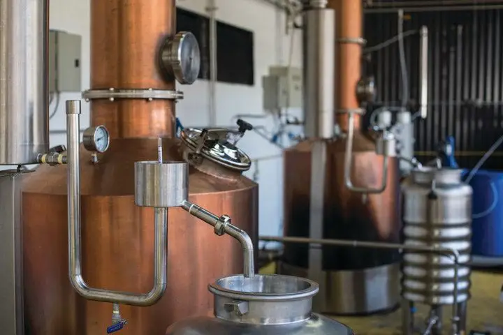 Two copper stills in a warehouse
