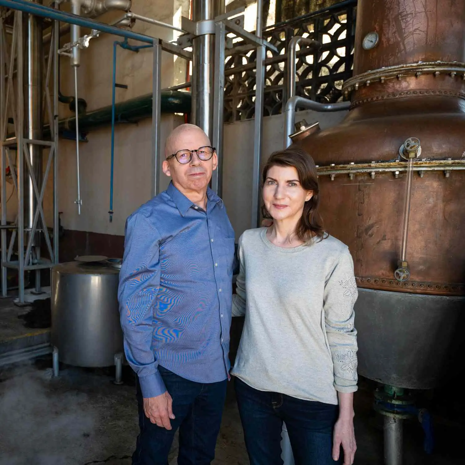 Grover and Scarlet Sanschagrin, the founders of Tequila Matchmaker, posing in front of a still