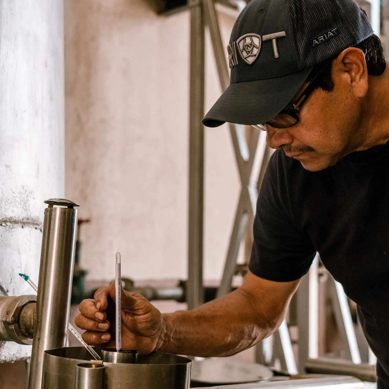 Cascahuin employee Jose Vargas checks the alcohol volume on a still. 