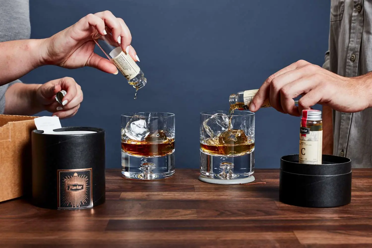 two people pouring liquor into glasses