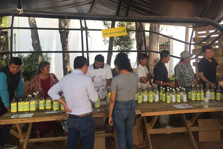 Guests line up in front of a vendor table at the Maestros del Mezcal tasting in Mexico City
