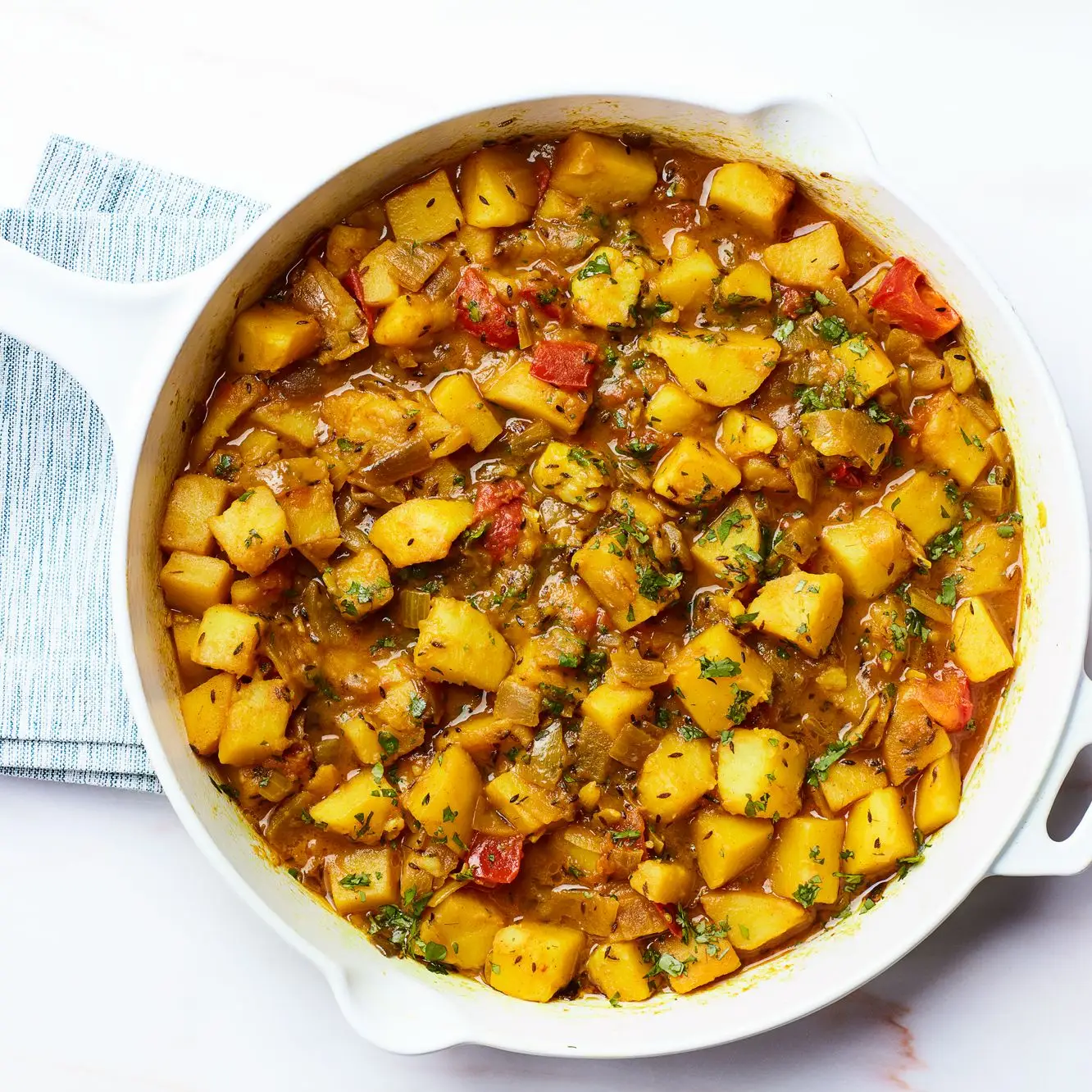 Batatas com cheiro de cominho com tomates (Ghurma aloo)