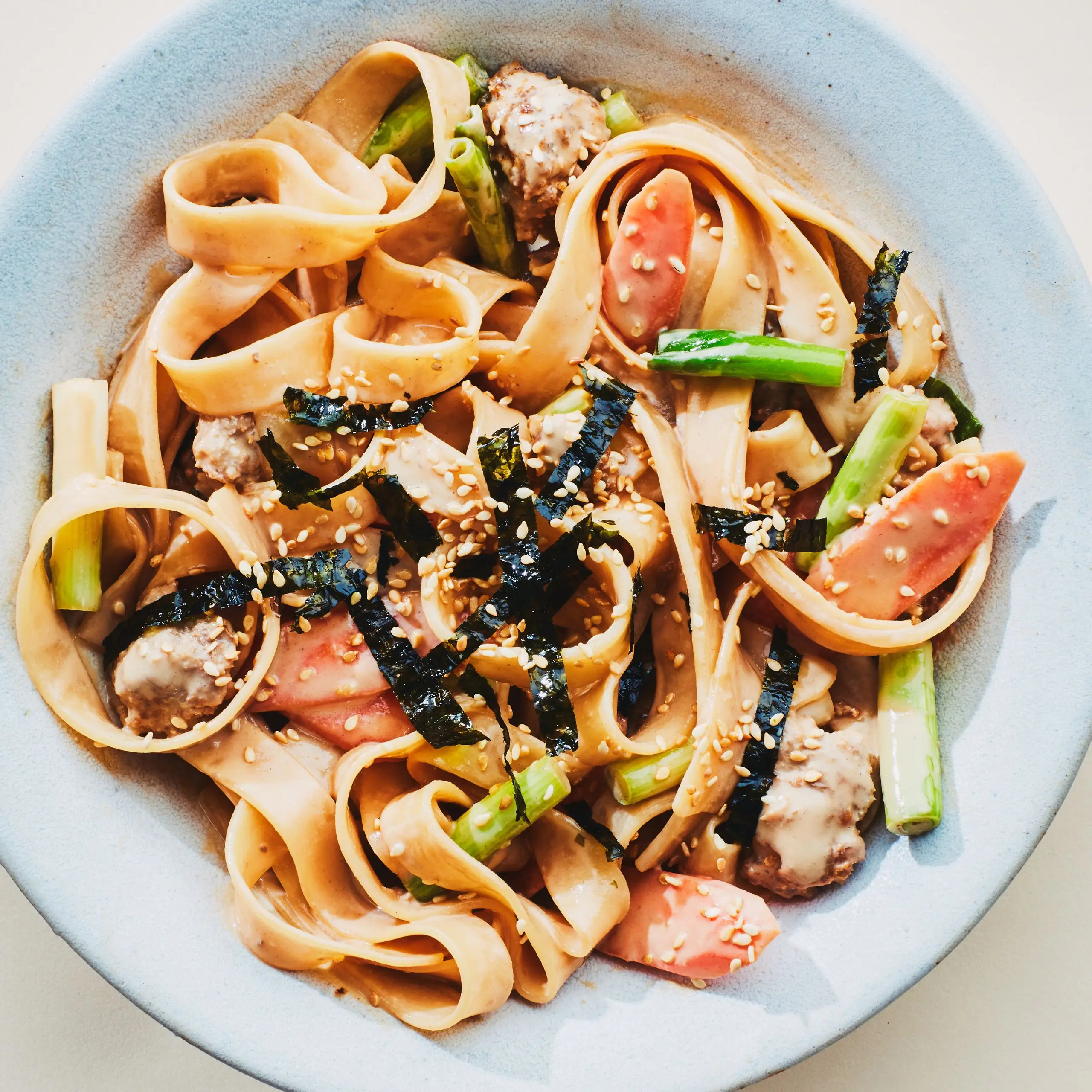 Macarrão quente de gergelim com cebolinha e carne de porco