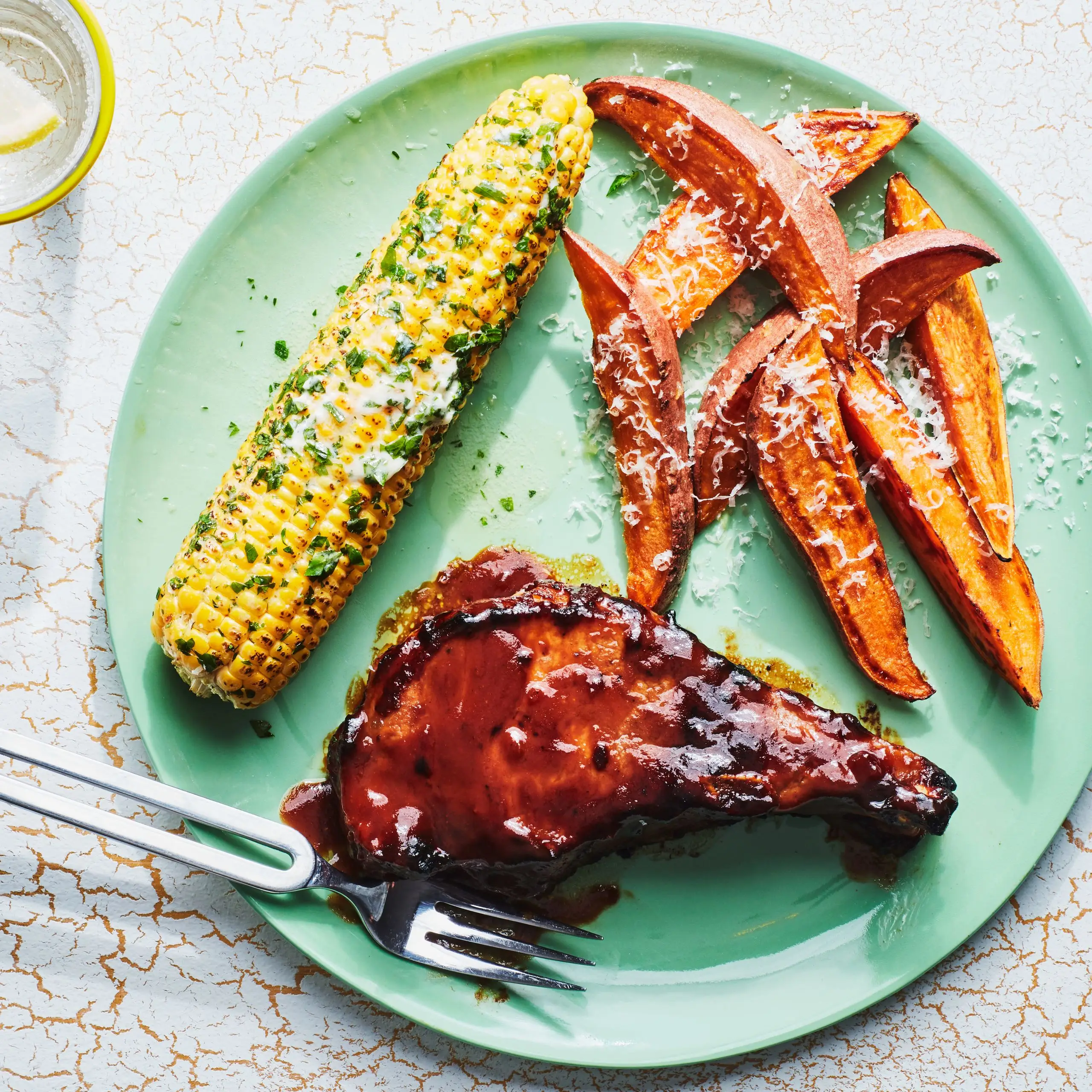 Costeleiros de porco com churrasco com manteiga de erva e batata-doce