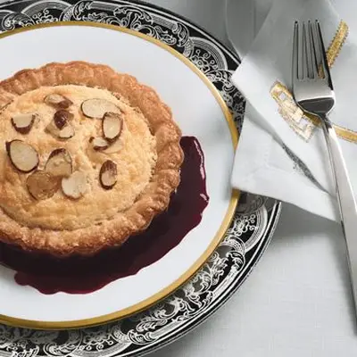 Tartas de suflê de limão com amêndoas açucaradas e molho de amora