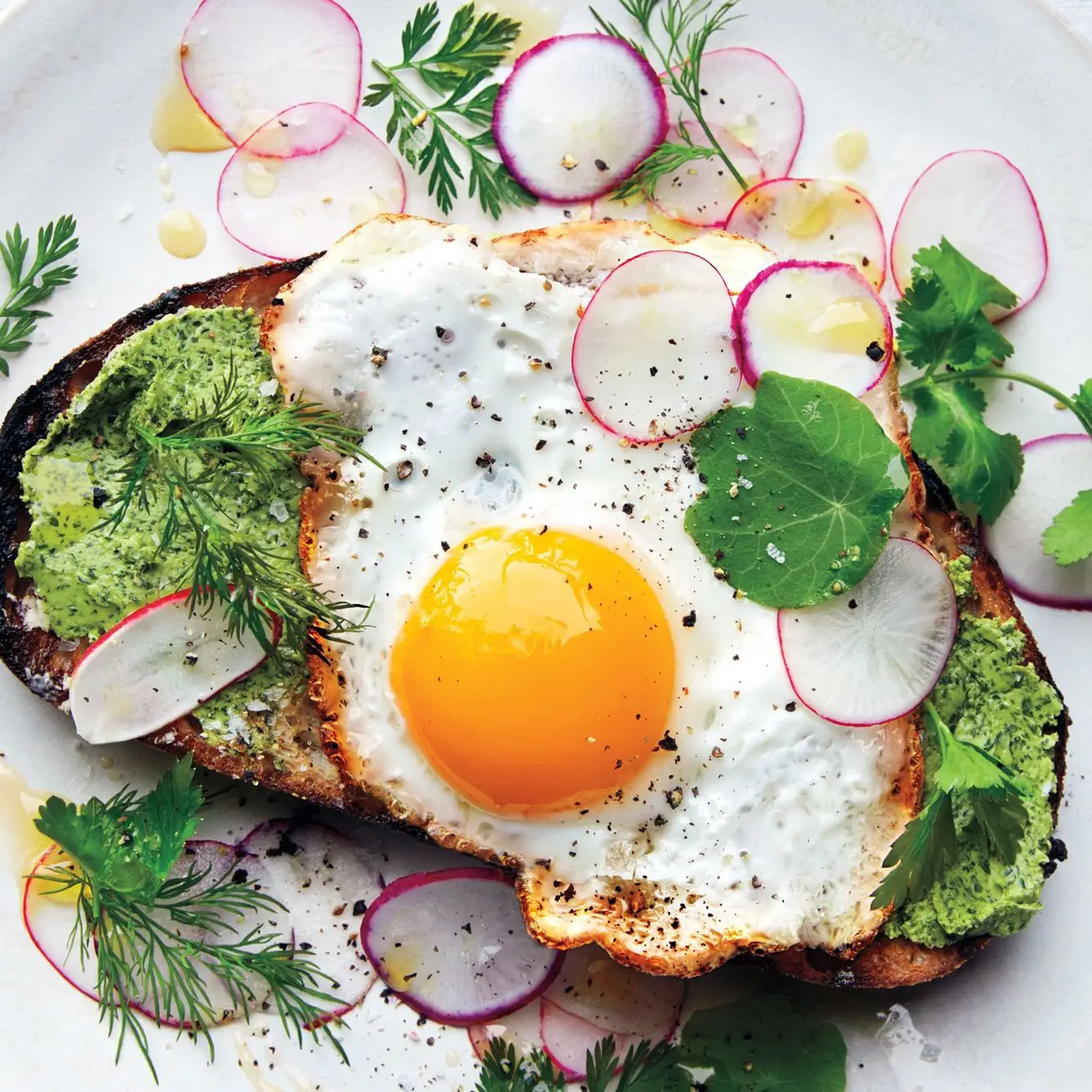 Gebratene Eier im Toast mit Kräutern und herzhaften Radieschen